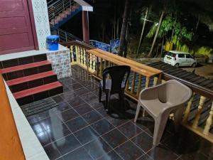 a porch with a bench and a table and a chair at Eden Homes in Honāvar