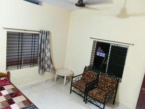 two chairs in a room with two windows at Eden Homes in Honāvar