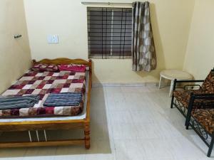 a bedroom with a bed and a window and a chair at Eden Homes in Honāvar