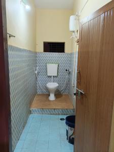 a bathroom with a toilet in a room with blue tiles at Eden Homes in Honāvar