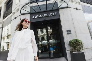 Eine Frau in einem weißen Kittel steht vor einem Geschäft in der Unterkunft JW Marriott Hotel Madrid in Madrid