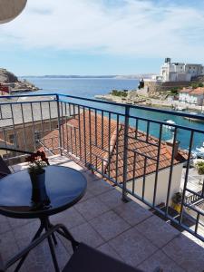 a balcony with a table and a view of the ocean at Apartman Jure in Jablanac