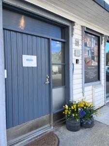 a door of a store with flowers in front of it at Fruenes in Volda
