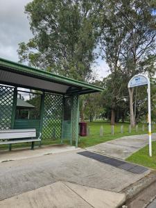 a bus stop with a bench in a park at The Pine Rest - Spacious & Central Haven in Brendale