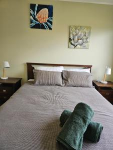 a bedroom with a bed with two green towels on it at The Pine Rest - Spacious & Central Haven in Brendale