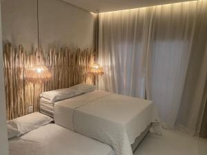 a bedroom with two beds and lights on the wall at Villa de Cactos in Piranhas