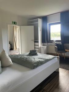 ein Schlafzimmer mit einem großen weißen Bett und einem Stuhl in der Unterkunft Design Quartier 6 Family&Business in Neunkirchen