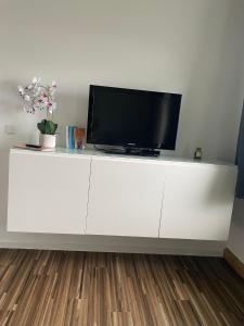 ein weißer Schrank mit einem Fernseher darauf in der Unterkunft Design Quartier 6 Family&Business in Neunkirchen