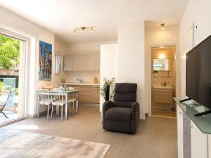 a kitchen and living room with a chair and a table at Emerald Apartment City Center in Lugano