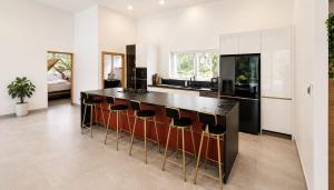 a kitchen with a bar with stools at villa Samuel in Koh Samui +3 photos
