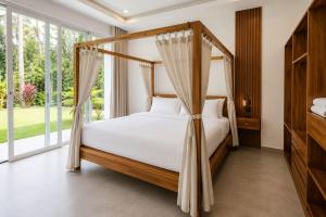 a bedroom with a canopy bed in front of a window at villa Samuel in Koh Samui