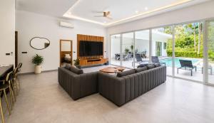 a living room with a couch and a tv at villa Samuel in Koh Samui