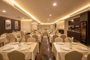 a banquet hall with white tables and white chairs at فندق برهان الهدى in Mecca