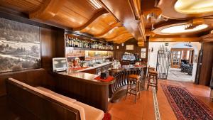 a bar in a restaurant with wooden ceilings at Hotel Regina Delle Dolomiti in Panchià +44 photos