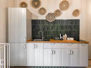 a kitchen with a sink and a refrigerator at Lues Incanto in Ragusa