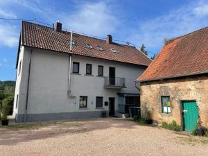 ein großes weißes Gebäude mit einer grünen Tür in der Unterkunft Design Quartier 6 Family&Business in Neunkirchen