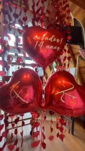 three red hearts are attached to a ceiling at Chalé nascer do sol in Massaranduba