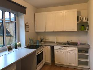 a kitchen with white cabinets and a sink at Auszeit in Hasselberg