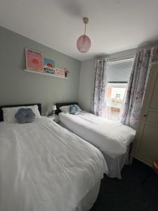 a bedroom with two beds and a window at Old Schoolhouse Coleraine in Coleraine