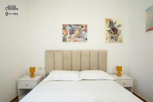 a bedroom with a white bed and two paintings on the wall at Joni's Condo 10 in Golem +17 photos