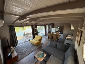 a living room with a couch and a table at Maison bord de Seine à 20 min de Paris in Villennes-sur-Seine