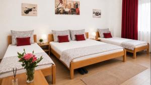 a bedroom with two beds and a vase of flowers at Becar Pyramids B&B in Visoko