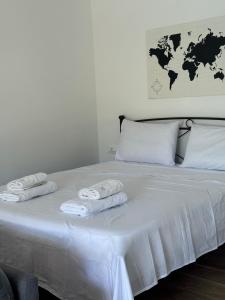 a white bed with two folded towels on it at The Country House in Áfra +13 photos