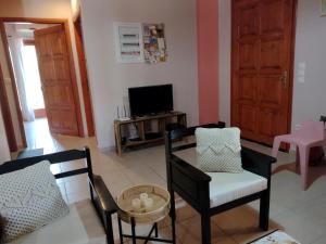 a living room with two chairs and a tv at IthakiHouse II in Vathi
