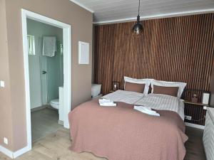 a bedroom with a large bed and a bathroom at Romantic Cottage in Fludir