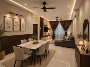 a dining room and living room with a table and chairs at JayR Homestay Ambience Residence in Malacca