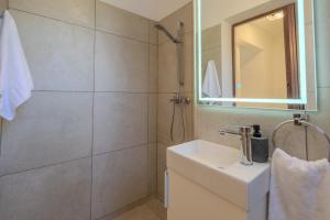 a bathroom with a sink and a shower with a mirror at San House 1 in Archangelos