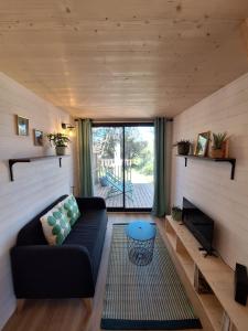 a living room with a couch and a large window at Tiny House L'esquirou in Pourrières