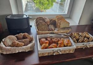a table with three baskets of different types of bread at Hotel Suonenjoki in Suonenjoki +29 photos