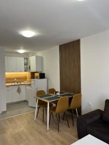 a living room with a table and chairs and a kitchen at Apartment D25 Pomorie in Pomorie