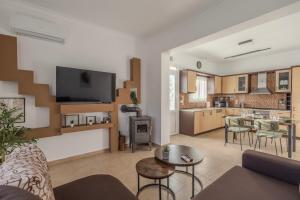 a living room with a couch and a table and a kitchen at San House 1 in Archangelos