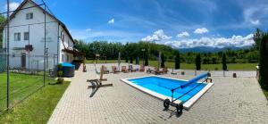 a swimming pool in a yard next to a building at Best Vila Valea Avrigului in Avrig