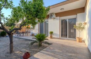 a patio of a house with a tree at San House 1 in Archangelos