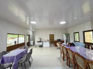 a dining room with tables and chairs with purple table cloth at Bakytzhan hotel in Kurmenty