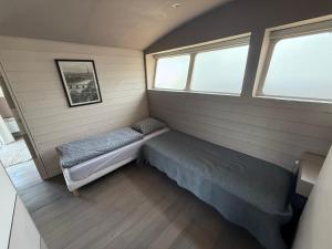 a small room with a bench and two windows at Maison bord de Seine à 20 min de Paris in Villennes-sur-Seine