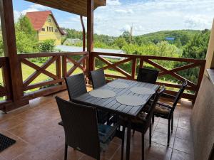 a wooden table and chairs on a balcony with a view at БУДИНОК сімейних ПРИГОД in Vodniki