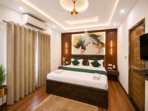 a bedroom with a large bed and a television at The Hotel Atlantis Suites Sigra Road Near Vishwanath Temple in Varanasi