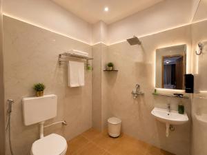 a bathroom with a toilet and a sink at The Hotel Atlantis Suites Sigra Road Near Vishwanath Temple in Varanasi