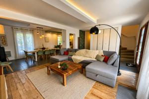 a living room with a couch and a table at Le Cercle des Éléments - Maison d'exception - Cinéma, Parking privé -Classé 4 étoiles in La Rivière-de-Corps +27 photos
