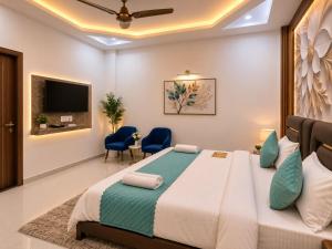 a bedroom with a large bed and blue chairs at The Hotel Atlantis Suites Sigra Road Near Vishwanath Temple in Varanasi +18 photos