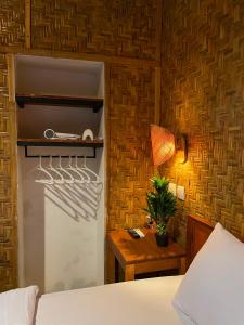 a bedroom with a bed and a white refrigerator at Bunga Lodge Tetebatu in Tetebatu