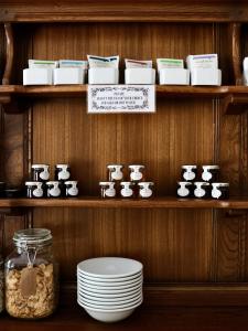 a shelf with bowls of food and plates on it at The Florence Guest House in Whitby +28 photos