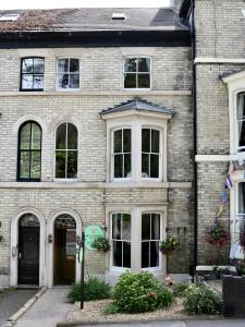 a brick house with a black door and white windows at The Florence Guest House in Whitby
