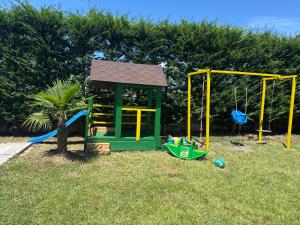 a small playground with a small house and a swing at KuneVain Guest House in Lezhë