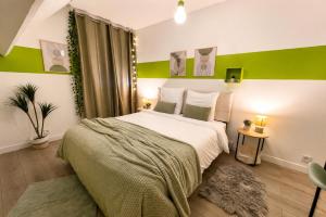 a bedroom with a bed and a green accent wall at Le Cercle des Éléments - Maison d'exception - Cinéma, Parking privé -Classé 4 étoiles in La Rivière-de-Corps