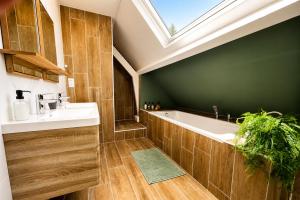 a bathroom with a sink and a tub and a skylight at Le Cercle des Éléments - Maison d'exception - Cinéma, Parking privé -Classé 4 étoiles in La Rivière-de-Corps
